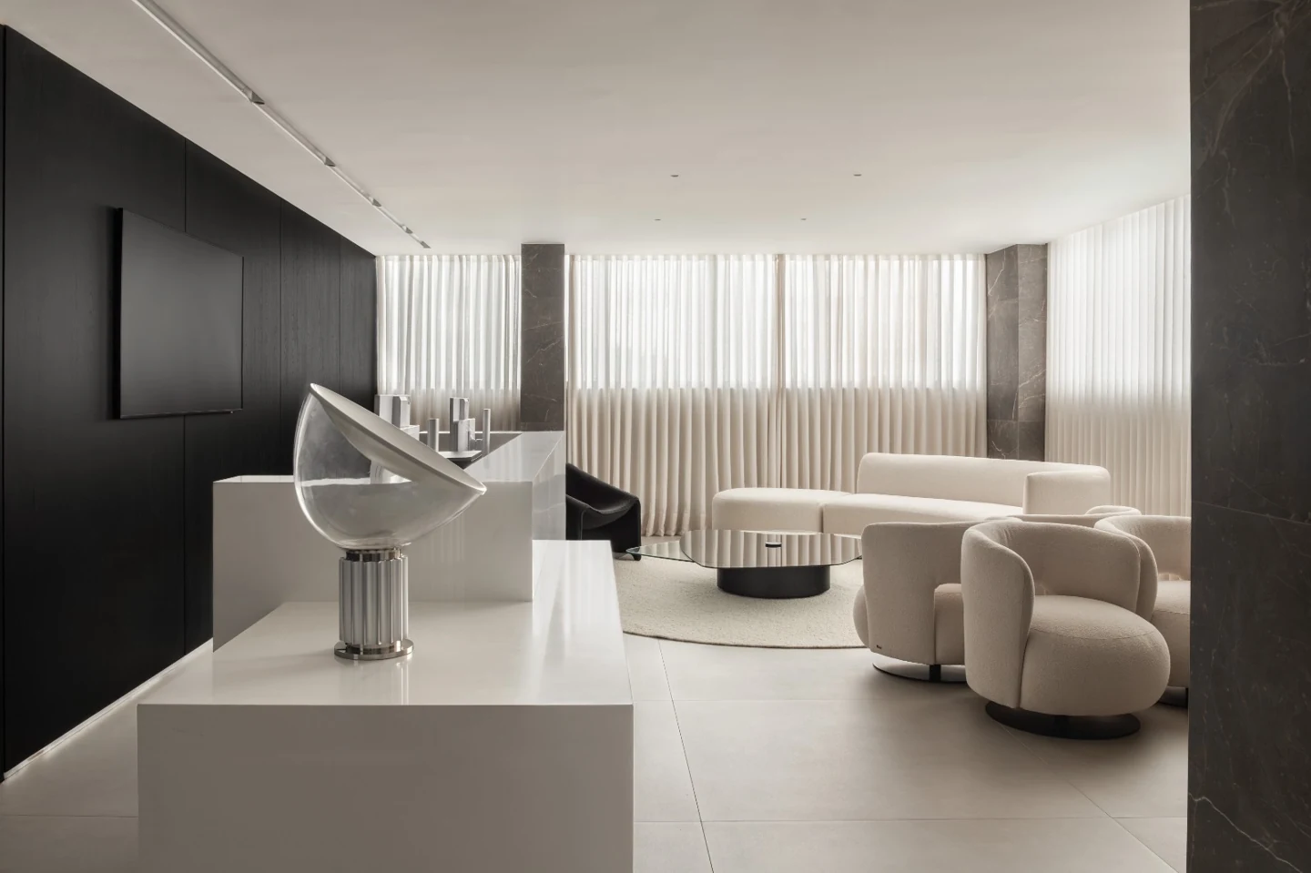 Recepção do consultório, com balcão claro, poltronas e ampla iluminação natural